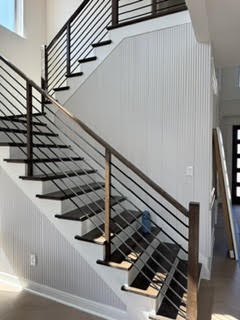 Finished stairwell with black rail and shiplap wall
